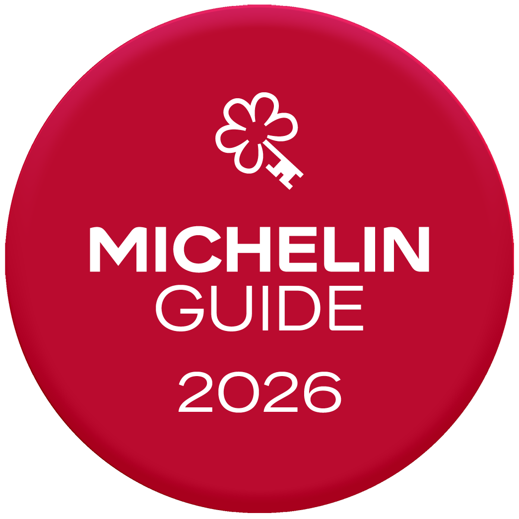 A red badge with a white bow icon and the text “MICHELIN GUIDE 2026” in bold lettering.