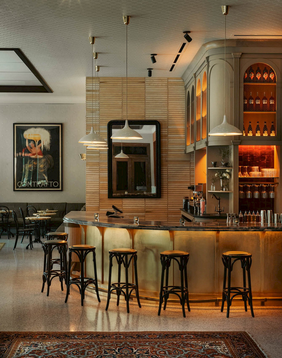 The brass-fronted bar at Bar Premio with bentwood stools and pendant lights